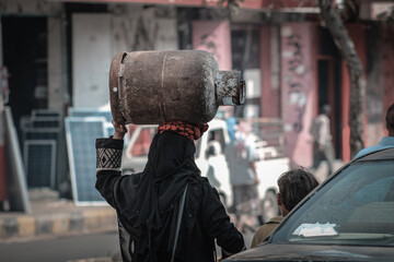 A Yemeni woman carrying household gas on her head due to the war and the siege on the city of Taiz, Yemen