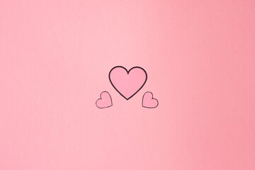 Overhead shot of several pink hearts on a background of the same color. Background for Valentine's day. Horizontal photography and copy space