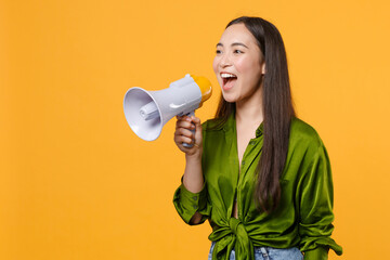 Cheerful funny excited attractive young brunette asian woman 20s wearing basic green shirt standing...