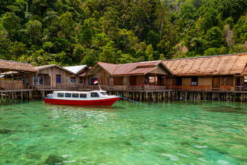 Fototapeta na wymiar Boat on the green coral ocean in Sawai, Maluku, Indonesia