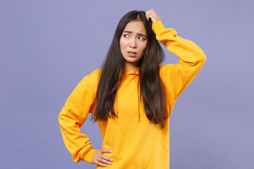 Preoccupied puzzled worried young brunette asian woman 20s wearing casual basic yellow hoodie...