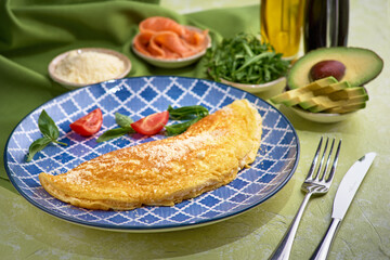 Classic omelette. Classic egg omelet with cherry tomatoes and arugula salad.