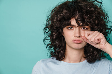 Caucasian unhappy curly girl posing and crying at camera