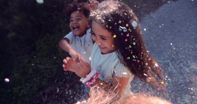 Confetti falling on african-american little girl smiling outdoors