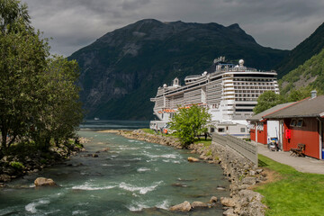 Fototapeta na wymiar cruise ship docked at the end of a fjord in a small Norwegian town