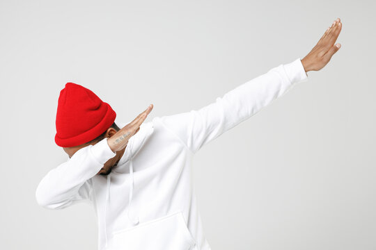 Young African American Man 20s In Basic Casual Streetwear Hoodie Doing Dab Hip Hop Dance Hands Gesture, Youth Sign Hiding And Covering Face Isolated On White Colour Wall Background, Studio Portrait.