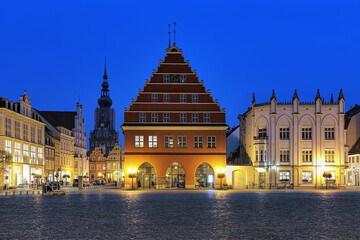 Greifswald, Germany. Evening view of Market square with Town Hall (center), Town Hall Pharmacy (right) and Cathedral of St. Nicholas (left on background).