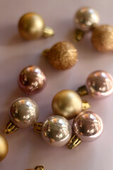 Christmas baubles in gold and pink tones. Selective focus, pink background.