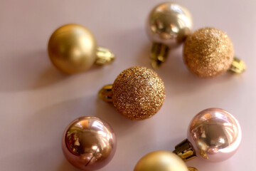 Christmas baubles in gold and pink tones. Selective focus, pink background.