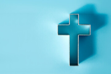 Obraz premium Church worship, salvation concept. Silhouette of christian cross on blue background, soft bokeh lights background. Copy space. Faith symbol in Jesus Christ. Holy cross for Christmas, Easter day
