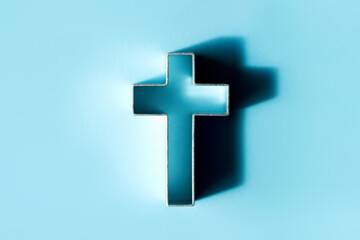 Silhouette of christian cross on blue background, soft bokeh lights background. Copy space. Church worship, salvation concept. Faith symbol in Jesus Christ. Holy cross for Christmas, Easter day