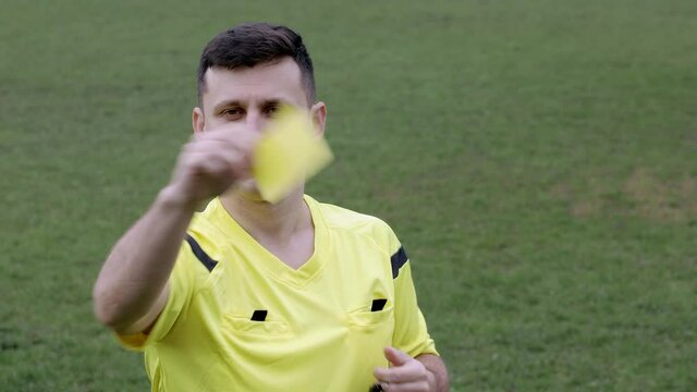 Football Soccer referee whistles and shows penalty and yellow, red card