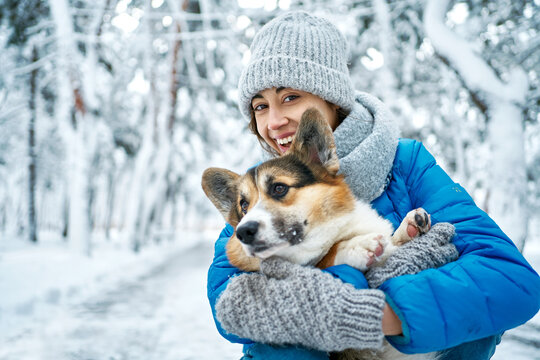 Pets, People And Season Concept. Well Dressed Happy Girl And Corgi Dog Outdoors In Winter