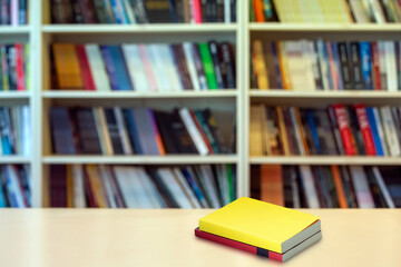 top view book  standing wooden table in front of bookcase