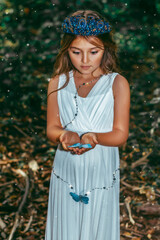 Cute little princess girl with blue butterflies in the forest. Art processing