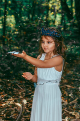 Cute little princess girl with blue butterflies in the forest. Art processing