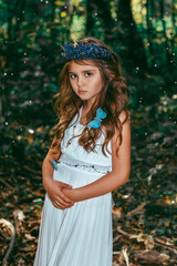Cute little princess girl with blue butterflies in the forest. Art processing