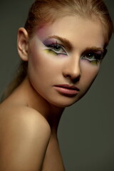 Fototapeta premium portrait of a beautiful girl with skillful makeup on a dark background