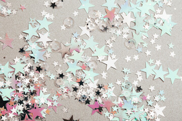 Sparkling and holographic stars on silver background. Festive concept. Macro.