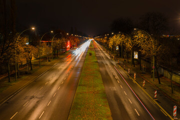 Fototapeta na wymiar Light trails from cars on a street at night, a street at night in Berlin, Adlergestell in Berlin, Germany