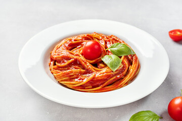 Spaghetti with tomato sauce and basil in white plate