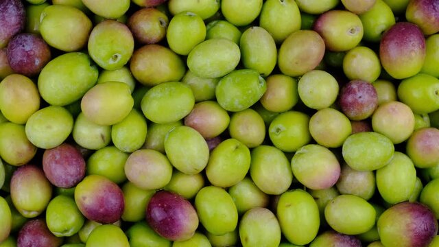 Olives. Pile of green olives rotating top view.