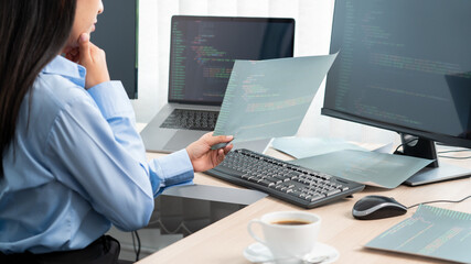 Asian woman programmer typing source code with computer pc for Developing program or application in her office.
