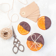Candied sliced oranges covered with chocolate, making sweet gifts for Christmas, top view, square