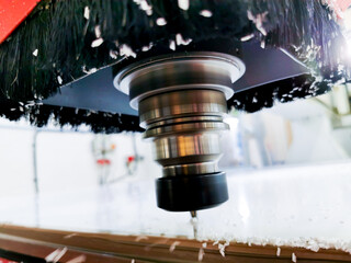 High speed CNC machine cutting through a plastic board.
