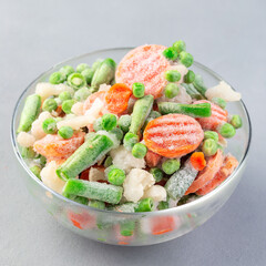 Frozen vegetables in glass bowl, square format, closeup