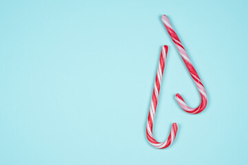 Two candy canes on a light blue background
