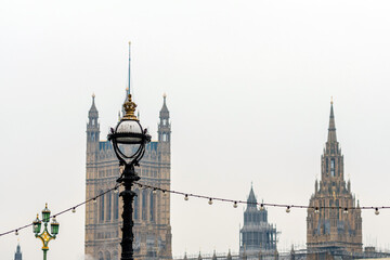 Dolphin lamp standard on Thames Embankment in London at the Westminster Bridge, bloored Westminster Abbey on background