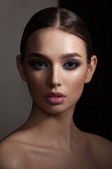 portrait of a beautiful girl with skillful makeup on a dark background