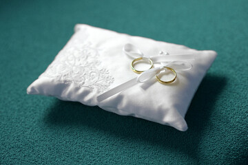 Two gold wedding bands with white bows