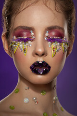 Fototapeta premium portrait of a beautiful girl with skillful bright fantasy makeup