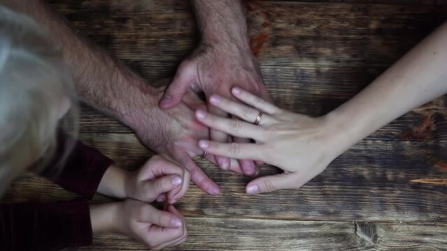 A friendly family joins their hands as a sign of joint success.