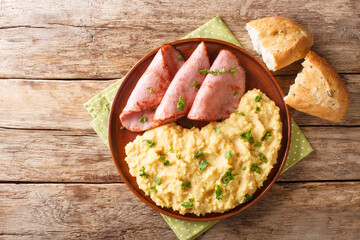 English pea pudding with fried ham served with bread close-up in a plate on the table. horizontal...