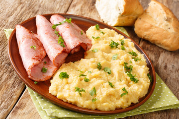 Delicious traditional English pease pudding with roasted ham close-up in a plate on the table. horizontal