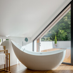 Stylish freestanding bathtub in attic bathroom