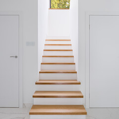 White corridor with wooden stairs