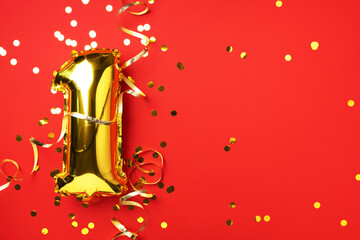 Gold foil balloon number and digit, one 1. Birthday greeting card. Anniversary celebration event. Banner. Copy space. Stylish golden numeral, bright shiny glitter, red background. Numerical digit