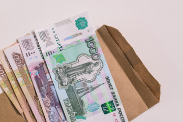 Russian money and envelope isolated on white background. Informal salary payment concept. Salary in an envelope or bribe. Avoiding company taxes. Shadow business