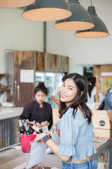 Obraz premium Beautiful women order coffee drink stand on counter in cafe