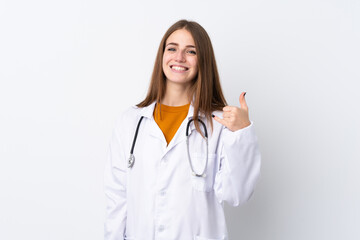 Fototapeta premium Young woman over isolated background wearing a doctor gown and making phone gesture