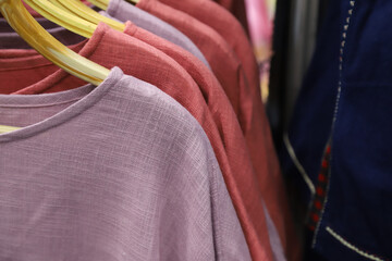 Closeup of purple cotton cloths on clothing rack.