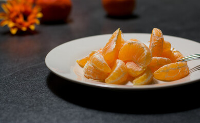 peeled tangerine in pieces on a plate