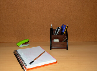 Desk with notebook and writing material in a warm environment