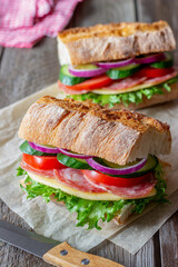 Sandwich with sausage, cheese, green salad, tomatoes, cucumbers and onions. Fast food. Breakfast. Healthy eating.