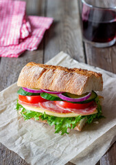 Sandwich with sausage, cheese, green salad, tomatoes, cucumbers and onions. Fast food. Breakfast. Healthy eating.