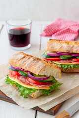 Sandwich with sausage, cheese, green salad, tomatoes, cucumbers and onions. Fast food. Breakfast. Healthy eating.